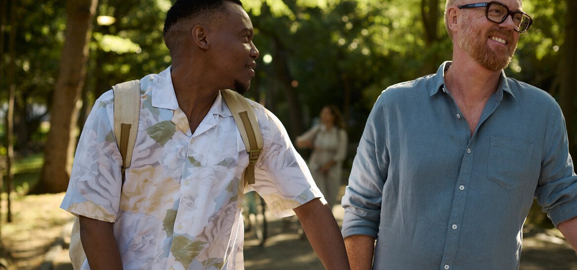 Two middle aged men walking and talking to each other 