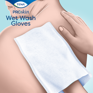 Person helping someone getting washed with TENA Wet Wash Gloves
