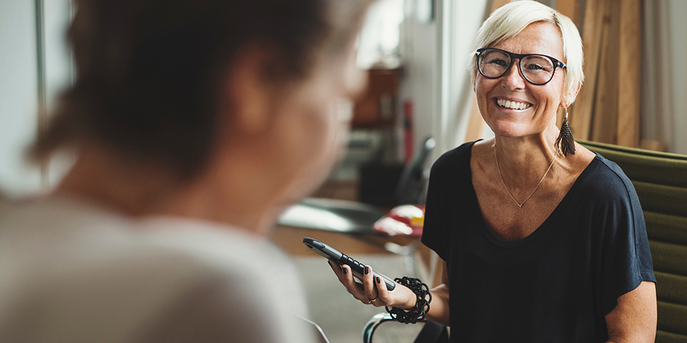 Woman with laptop smiling whilst wearing TENA